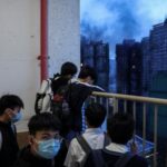 Secondary school students watch the aftermath of the major fire