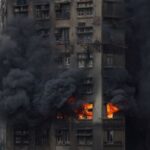 Thick smoke billows from the upper floors of a residential