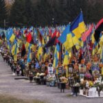 A man visits graves of the killed Ukrainian defenders, at