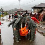 Rescuers carry a body bag of a victim recovered from