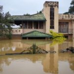 A house partially submerged by floods stands in an area
