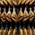 FILE PHOTO: Iberian ham legs hang at the Gourmets Fair