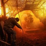 Ukrainian serviceman fires towards Russian troops from a position on