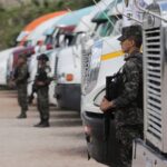 Members of security forces guard trucks holding ballot boxes, in