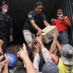 Survivors collect relief supplies in an area affected by deadly