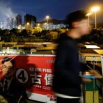 FILE PHOTO: Man walks past campaign posters ahead of the