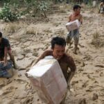 Survivors collect relief supplies in an area affected by a