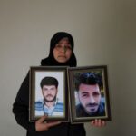 Amina Beqai, holding a photo of her husband and brother,