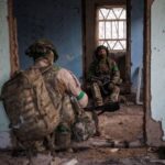 Ukrainian servicemen hide from a Russian combat drone in a