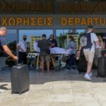 Tourists enter the departures lounge of the airport of Heraklion,