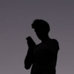 A man uses a mobile phone at dusk in Brisbane