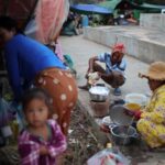 People gather at a refugee camp after evacuation, in Srei