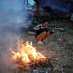 People gather at a refugee camp after evacuation, in Srei