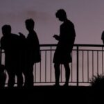 People use their mobile phones at dusk in Brisbane
