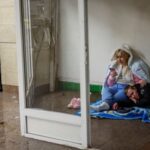 People take shelter inside a metro station during a Russian