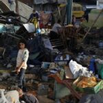 Palestinians inspect the damage at a school sheltering displaced people,