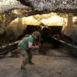 Ukrainian service members fire a 2A36 Giatsint-B howitzer towards Russian