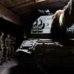 Ukrainian service members appear next to a captured Russian 2S19