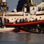 FILE PHOTO: Crew members and rescued migrants are seen on