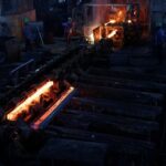 FILE PHOTO: Casted steel bars emerge from a casting machine