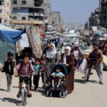 Palestinians carry their belongings as they flee their homes after