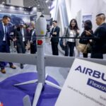 Visitors look at an Airbus Flexrotor drone on display at