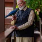 India’s PM Modi looks at a Spix’s macaw during the