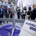 Visitors look at an Airbus Flexrotor drone on display at