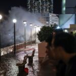 Residents watch rough waves from the shore before Super Typhoon