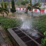 Seawater gushes from a drainage outlet as storm surge from