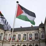 The Palestinian flag flies in front of the city hall