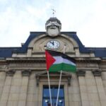 The Palestinian flag flies on the facade of city hall