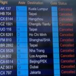 FILE PHOTO: A departure board displays flight cancellations at Hong