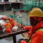 Workers use a robotic pump to remove floodwater from inundated