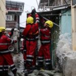 Firefighters secure a loose cable damaged by Super Typhoon Ragasa