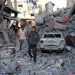 Palestinians inspect the site of Israeli strikes on houses at