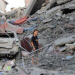 Palestinians inspect the site of Israeli strikes on houses at