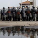FILE PHOTO: Police officers in riot gear stand guard outside