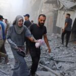 Palestinians inspect the site of Israeli strikes on a house,