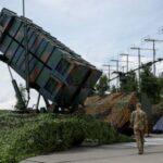 FILE PHOTO: Ukrainian service members walk next to a launcher