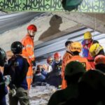Search and rescue officers search for victims in the rubble