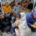 A relative of a victim of a collapsed building reacts