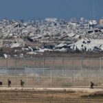 Israeli soldiers walk on the on Israeli side of the