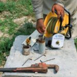 An employee of Punjab Irrigation Department, uses a dipmeter to