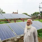Mohammad Naseem, 65, a farmer, stands beside his solar panel,