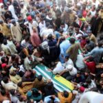 People attend the funeral of men, who were killed during