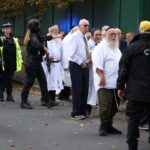 People near the scene following an incident outside a synagogue,