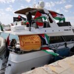 FILE PHOTO: People gather on a boat from a flotilla