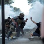 People protest during a standoff with ICE and federal officers
