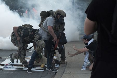 People protest during a standoff with ICE and federal officers